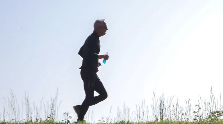 Connect to unlock better health outcomes - A man is jogging on the grass.